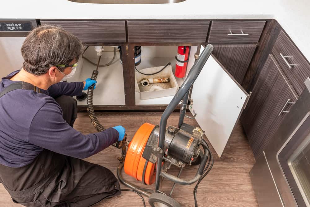 overhead of plumber working under a sink